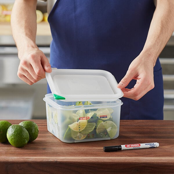 A person opening a white Araven plastic food storage container with a lid.