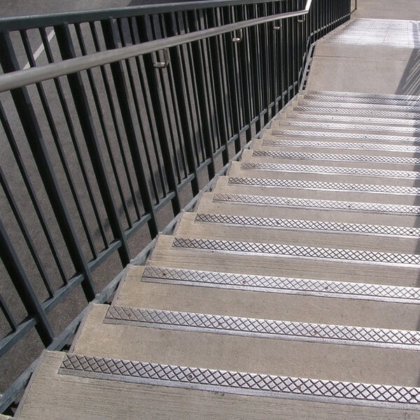 A close-up of Wooster Alumogrit cast aluminum stair tread nosing on a set of stairs.