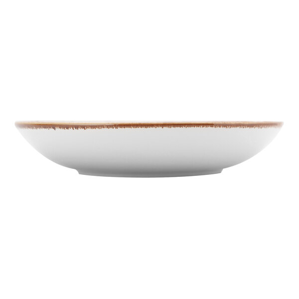 A white Tuxton pasta bowl with a brown speckled rim.