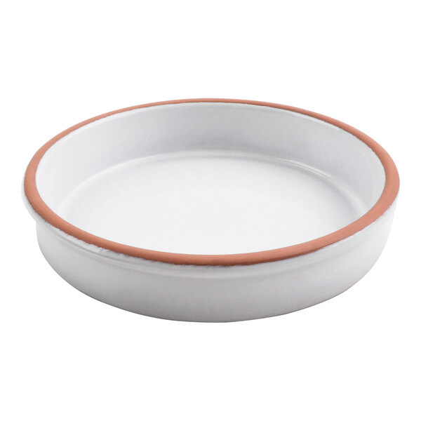 A white terracotta casserole dish with a brown rim.