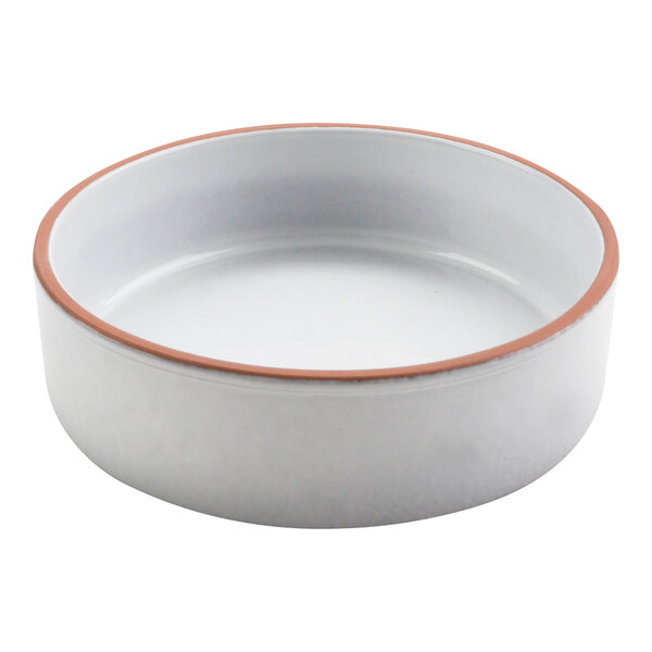 A white terracotta casserole dish with a brown rim.