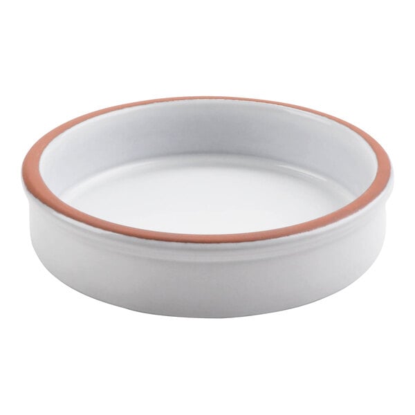 A white terracotta casserole dish with a brown rim.