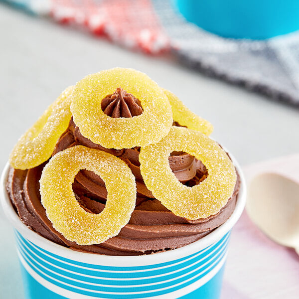 A cup of ice cream with Vidal Gummy Pineapple Rings on top.