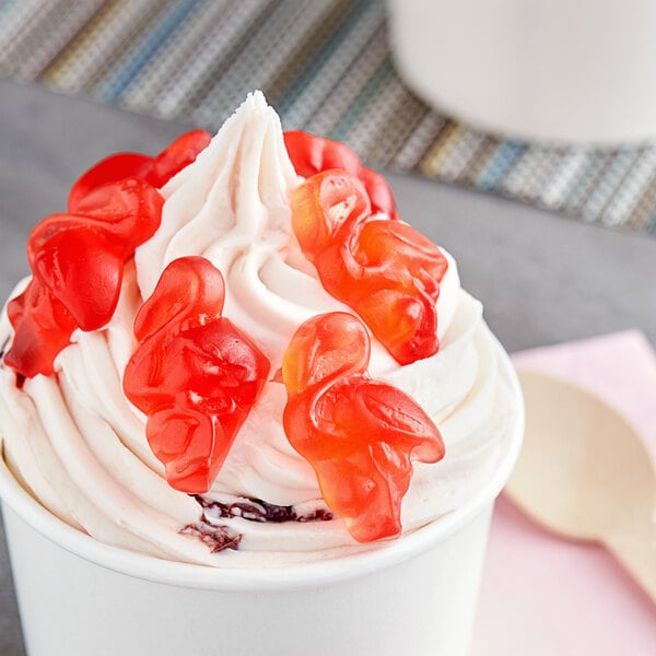 A cup of ice cream with pink Vidal gummy flamingos on top.