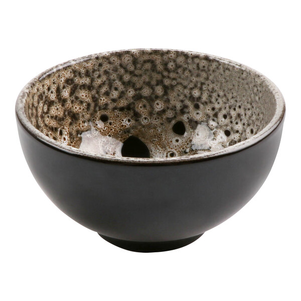 A cheforward terracotta bowl with a white and brown speckled surface.