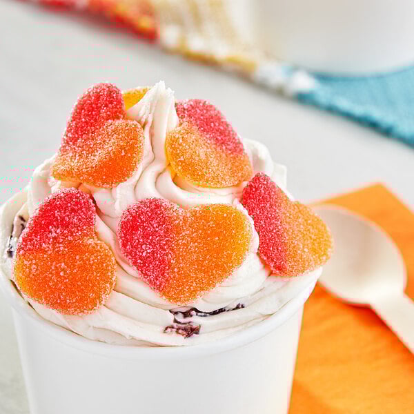 A bowl of ice cream topped with Vidal Gummy Peach Hearts.