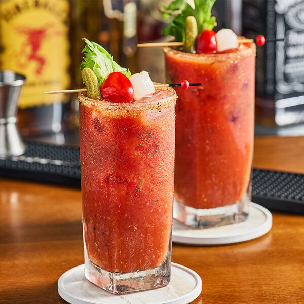 Two glasses of Sacramento Tomato Juice with garnish on top.