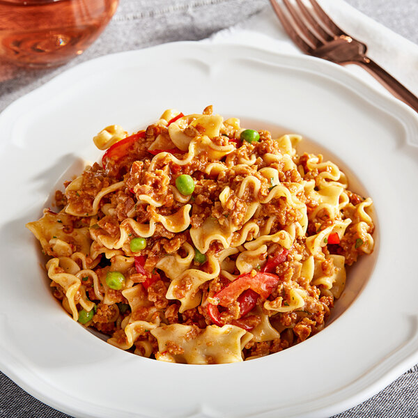 A plate of pasta with The BE Hive Chipotle Chorizo Crumbles and vegetables.