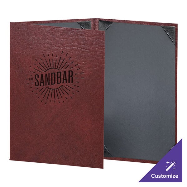 A red leather H. Risch, Inc. menu cover with a logo on a table in a bar.