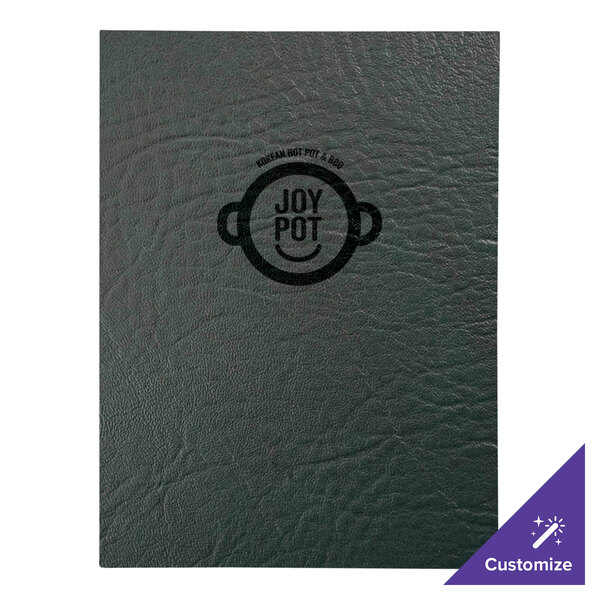 A green H. Risch, Inc. menu cover on a table with a black notebook with the word "joy" on it.