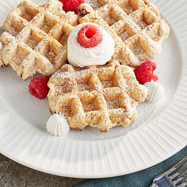 A plate of Vafels vegan maple Liege waffles with whipped cream and raspberries.