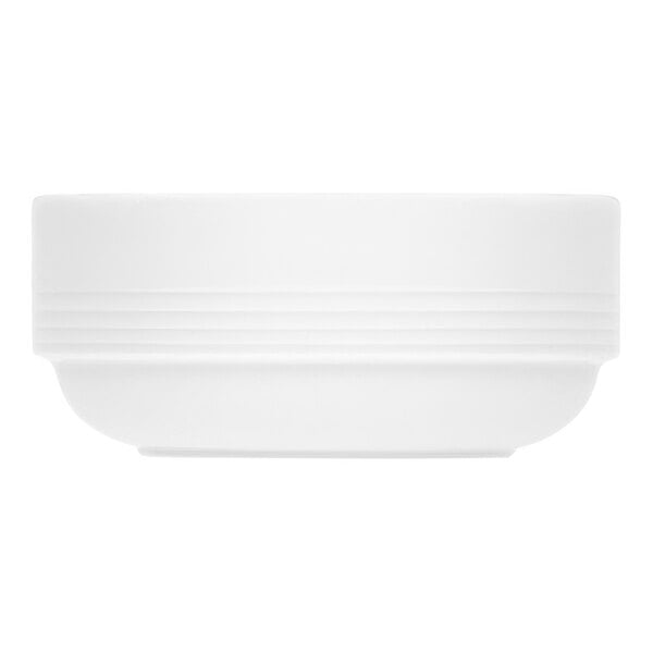 A stack of Bauscher bright white porcelain soup bowls with an embossed design.