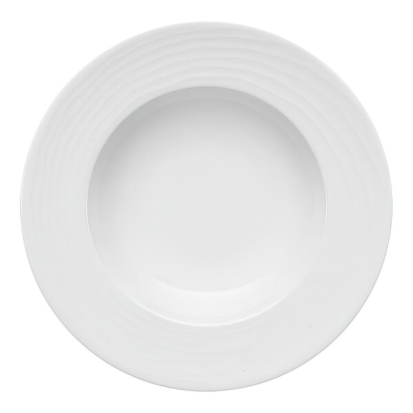 A close up of a Bauscher bright white porcelain plate with a circular rim and embossed pattern.