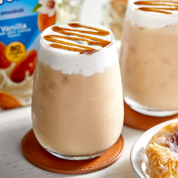 Two glasses of vanilla almond milk with a pastry.