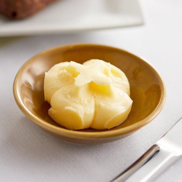 A Le Gall unsalted butter portion in a small bowl on a table.