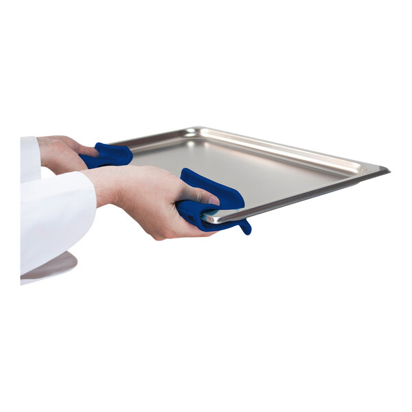 A person using an Araven blue silicone pot holder to hold a metal tray.