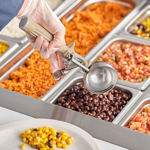 A person holding a Fourt&#233; Ivory Thumb Press Disher over a tray of food.