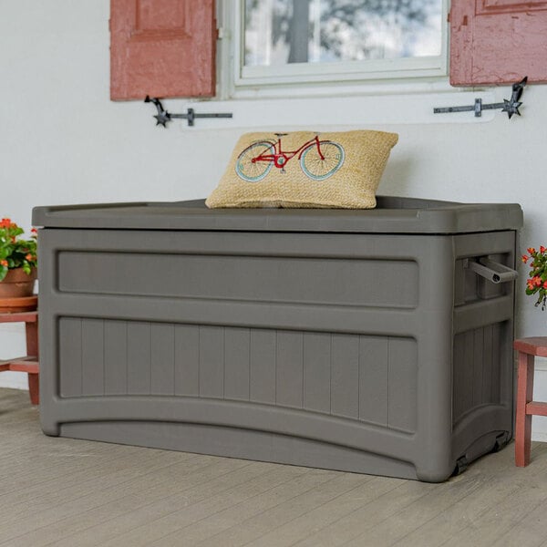 A Suncast grey plastic storage box with wheels.