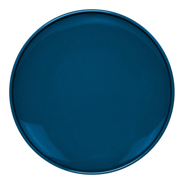 A close-up of a blue Front of the House Bevel porcelain plate with a white center.