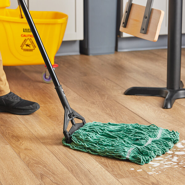 A person cleaning a floor with a Lavex Pro green rayon blend mop and bucket.