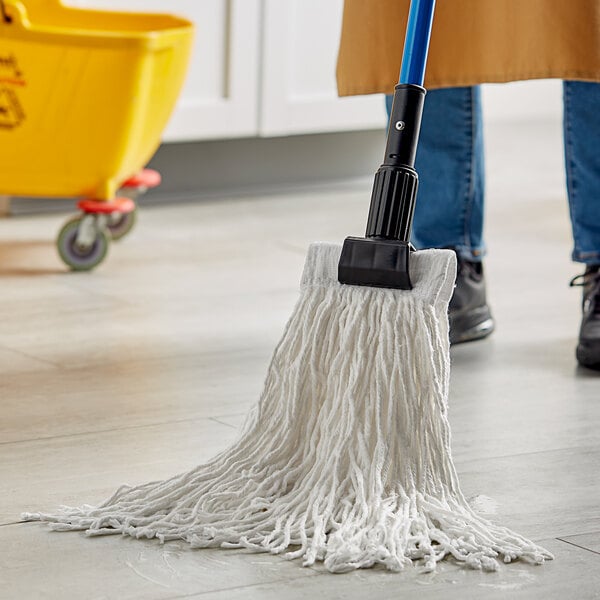 A person holding a Lavex White Rayon Cut-End Mop head and cleaning a floor.