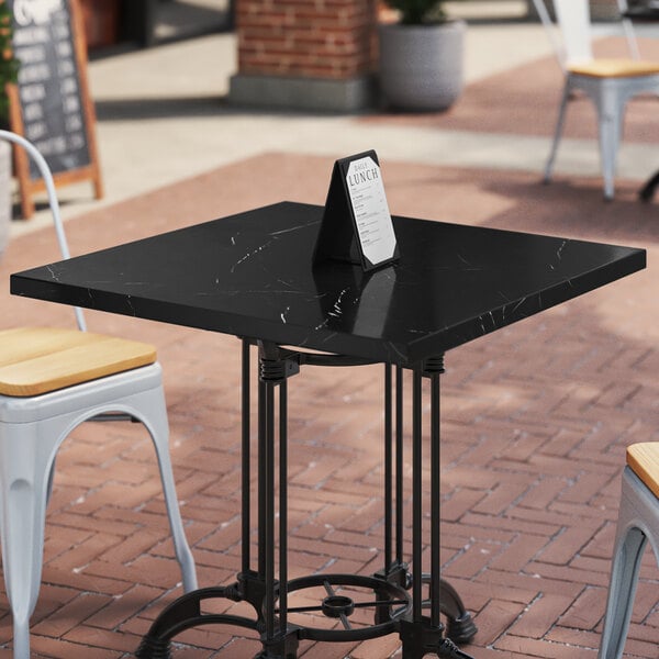 An Art Marble Furniture Italian black sintered stone table top on a black table with a menu on it.