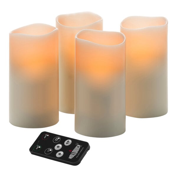 A group of Hollowick LED wax pillar candles with a remote control.