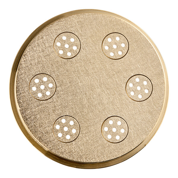 A circular gold pasta die with holes in it.
