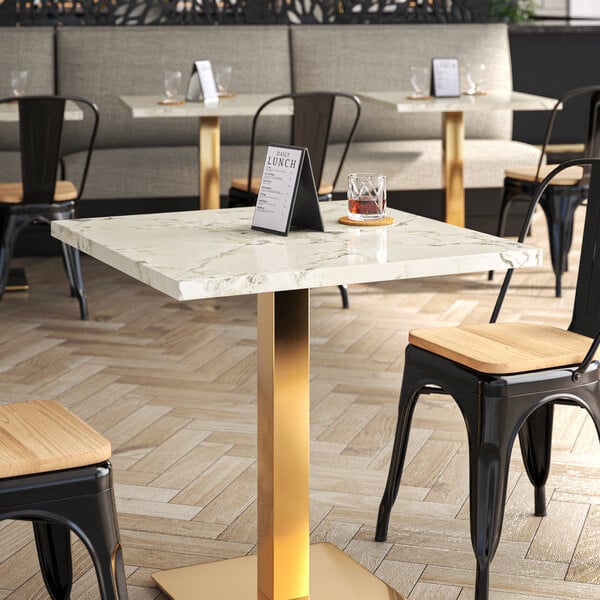 A white Art Marble Furniture Calacatta Sintered Stone table top on a table in a restaurant dining area.