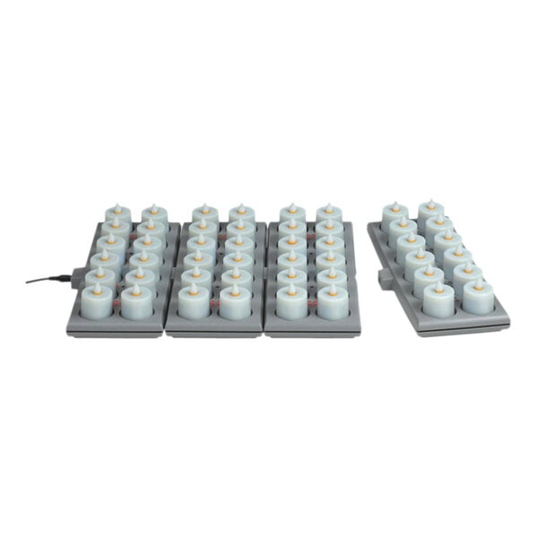 A group of amber Hollowick Platinum+ flameless candles on a charging tray.