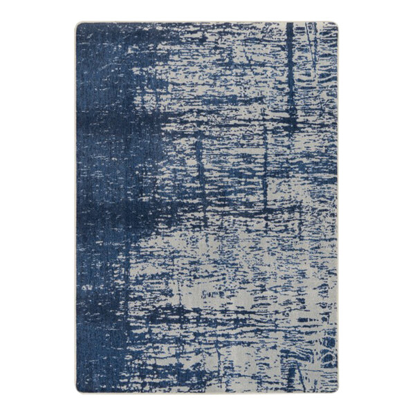 A close-up of a blue and white Joy Carpets High Tide area rug with a distressed look.