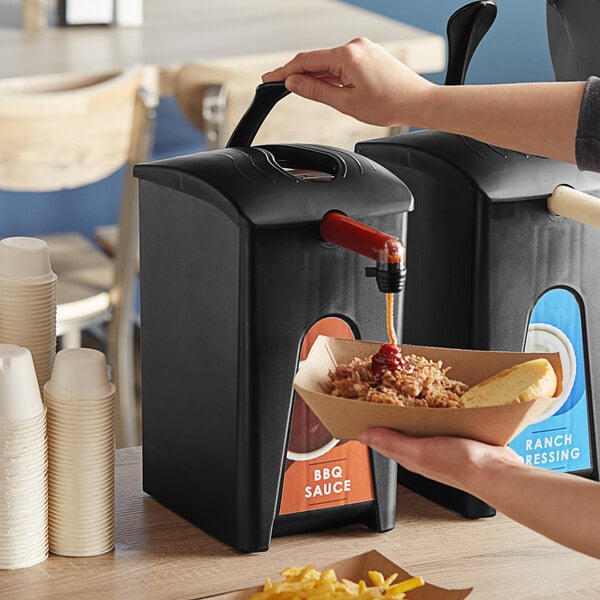 A hand using a ServSense BBQ pouch dispenser to pour sauce into a container of food.