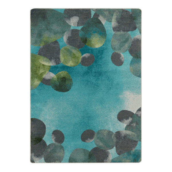 A teal area rug with blue and green circles and leaves on a patterned background.