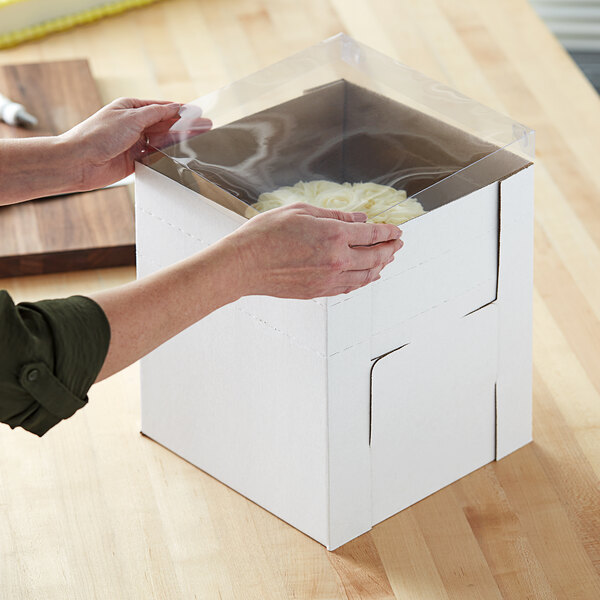 A person opening a white Enjay Flexbox with a plastic wrap cover.