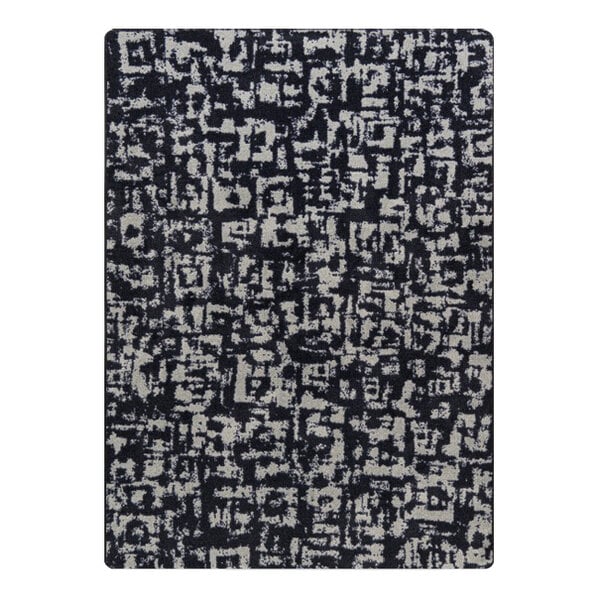 A close-up of a black and white Joy Carpets WorkSpace Block Print area rug with abstract designs.