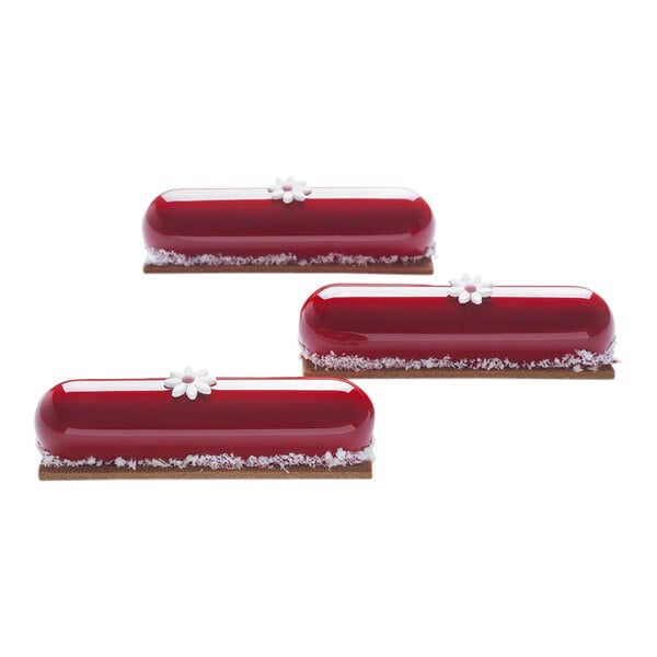 A group of red and white Pavoni cakes in a silicone mold with white flowers on top.