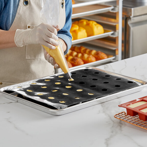 A person using a Pavoni Pavoflex sphere silicone baking mold.