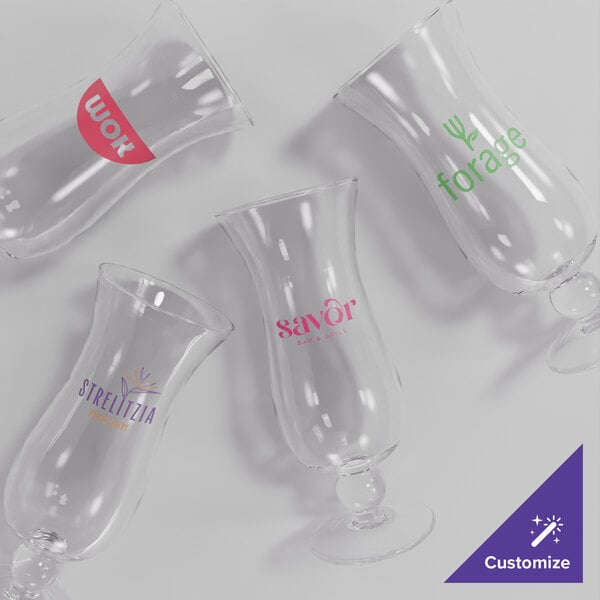 A group of Acopa Endure customizable hurricane glasses with various text colors.