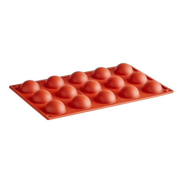 A red silicone baking mold with round holes.