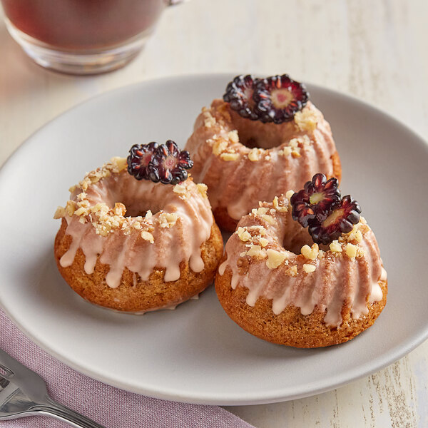 Three Pavoni Pavoflex Gugelhupf cakes with berries on a plate.