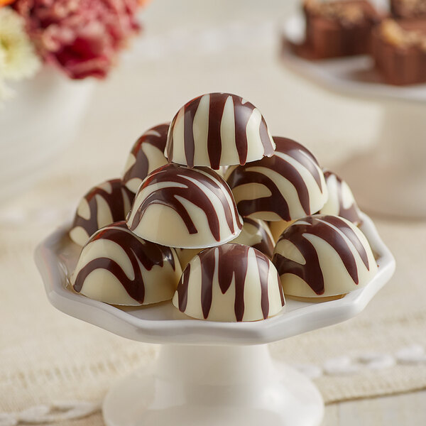 A close up of a chocolate candy in a red and white swirl.