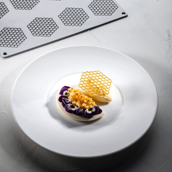 A Pavoni Gourmand honeycomb silicone baking mold on a table with food.