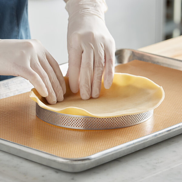 A gloved hand using a Pavoni Progetto Crostate tart ring to make a pie