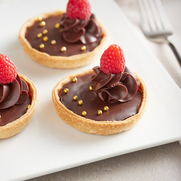 A Pavoni Formasil silicone mold with three chocolate desserts.