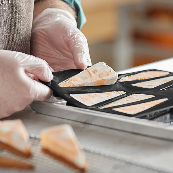 A person putting food into a Pavoni Pavoflex silicone baking mold.