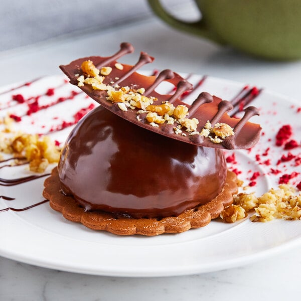 A chocolate dessert in a Pavoni Pavoflex semi-sphere baking mold with nuts on top.