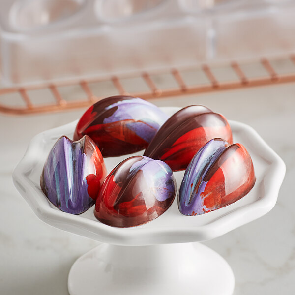 A white plate with heart shaped chocolates made with a Pavoni Praline candy mold.