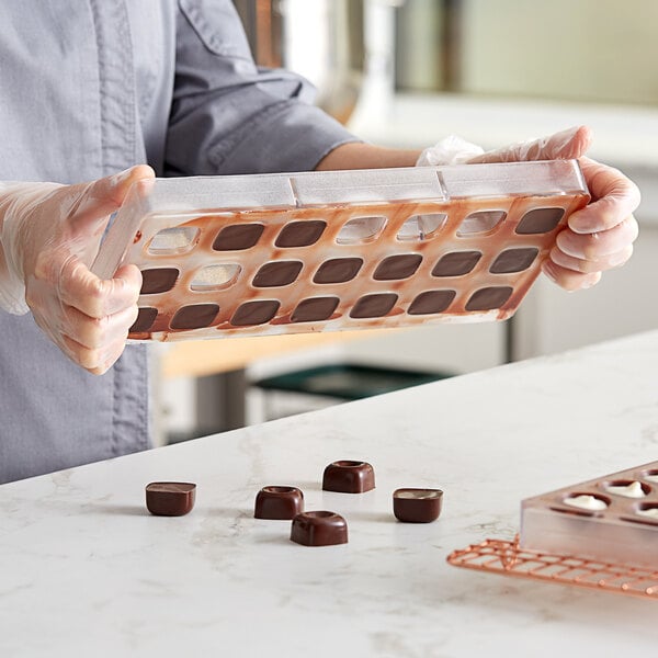 Closeup image of a chocolates being released from mold