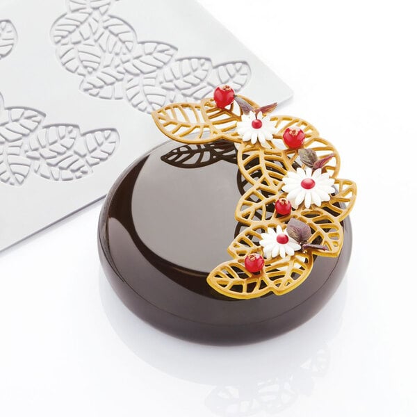 A chocolate cake with flowers and leaves on top made using a Pavoni Pavodecor 3 compartment leaves silicone baking mold.