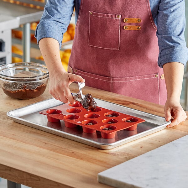 A woman using a Pavoni silicone muffin mold to make chocolate cupcakes.